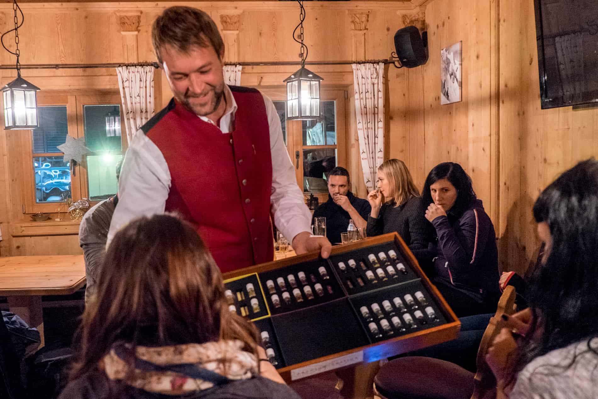 A group of people in a mountain hut being presented Scent Vials during Schnapps Tasting in Tirol Austria.