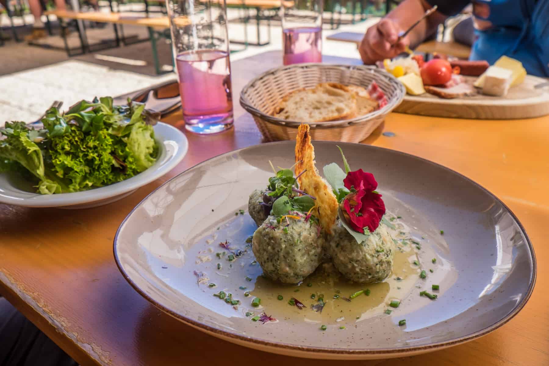 Traditional Austrian dumplings, garnished with red and green salad with homegrown herbs in St. Anton, served at the mountain hut Senn Hütte