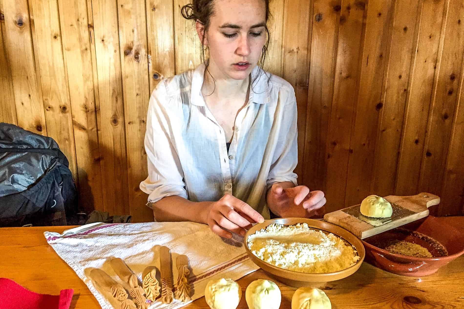 A woman demonstrates the making of traditional Slovenian Trnič hard cheese shaped like breasts.