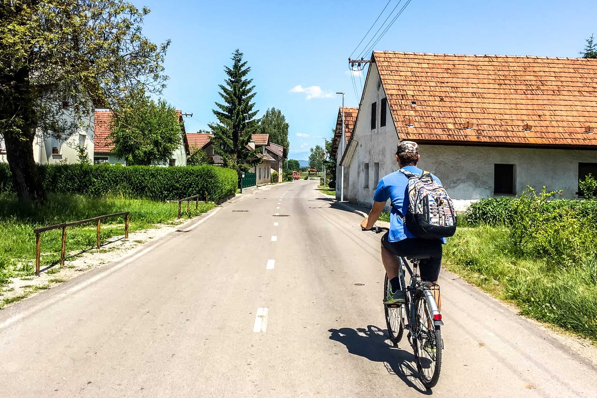 A bike tour guide leads the journey through a small Slovenian village in the countryside near Ljubljana city. 