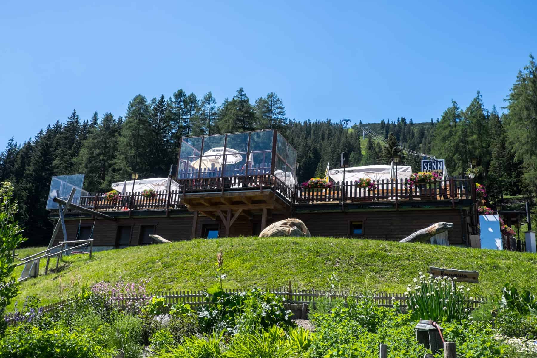 A view looking up to the Senn Hütte mountain hut in St.Anton, from the herb garden below, part of the Alpine Flowers and Herbs Way walking path