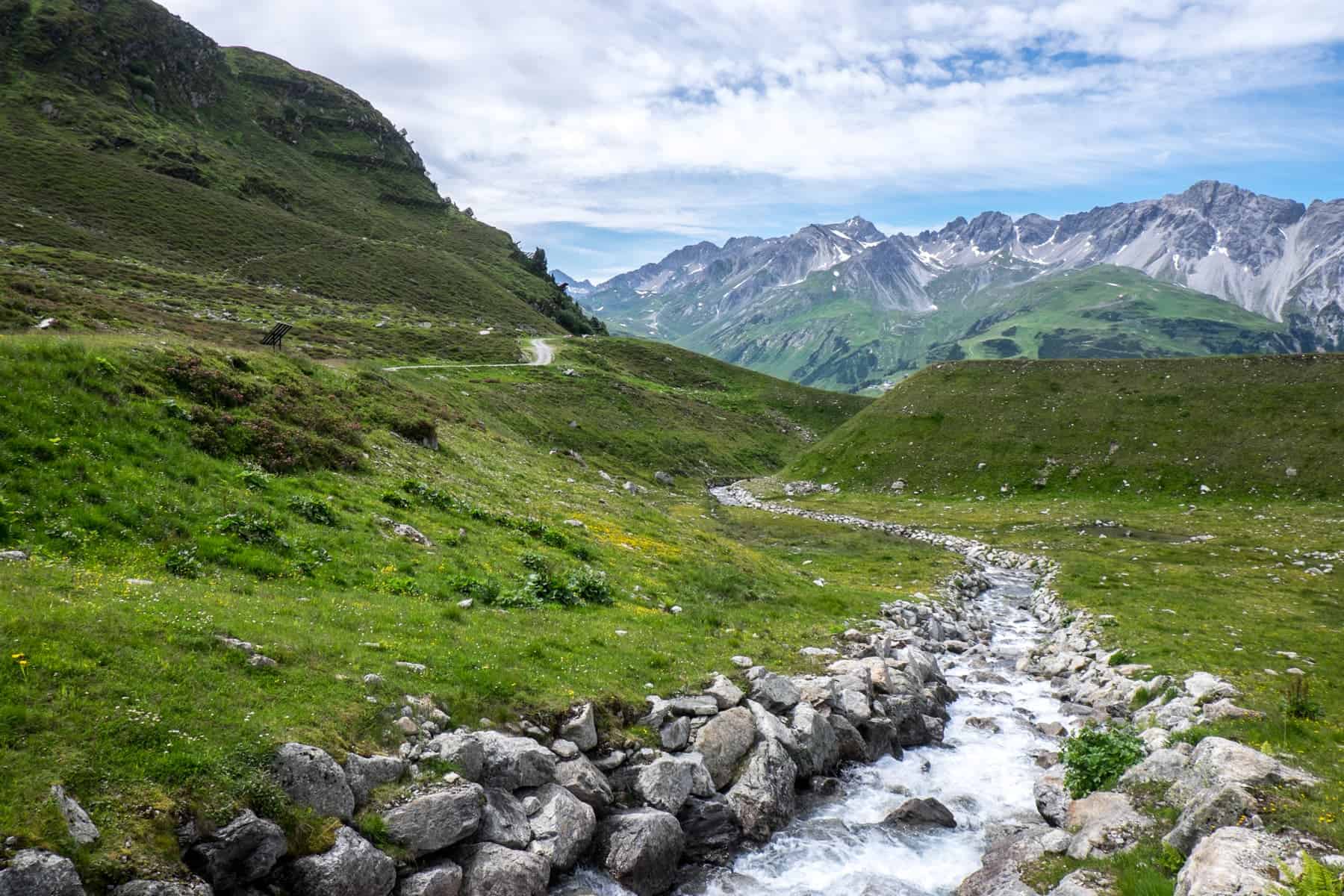 A river surrounded by silver rocks on a green mountain in St. Anton in Austria