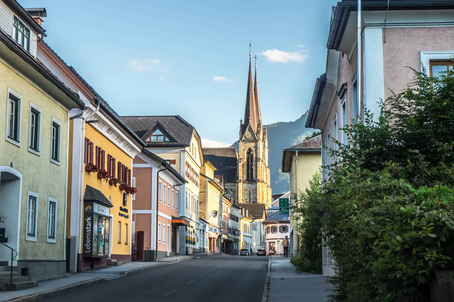 The golden light of the Cathedral and pastel yellow colours of the buildings in St. Johann in Salzburg city in Austria