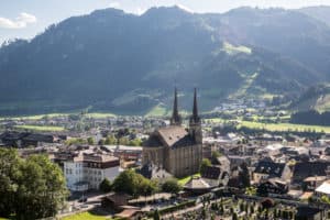 The twin-towers of the Cathedral, Pongauer Dom, in St. Johann im Pongau in Salzburg in Austria, dominate the city spread surrounding it in front of the low mountains.