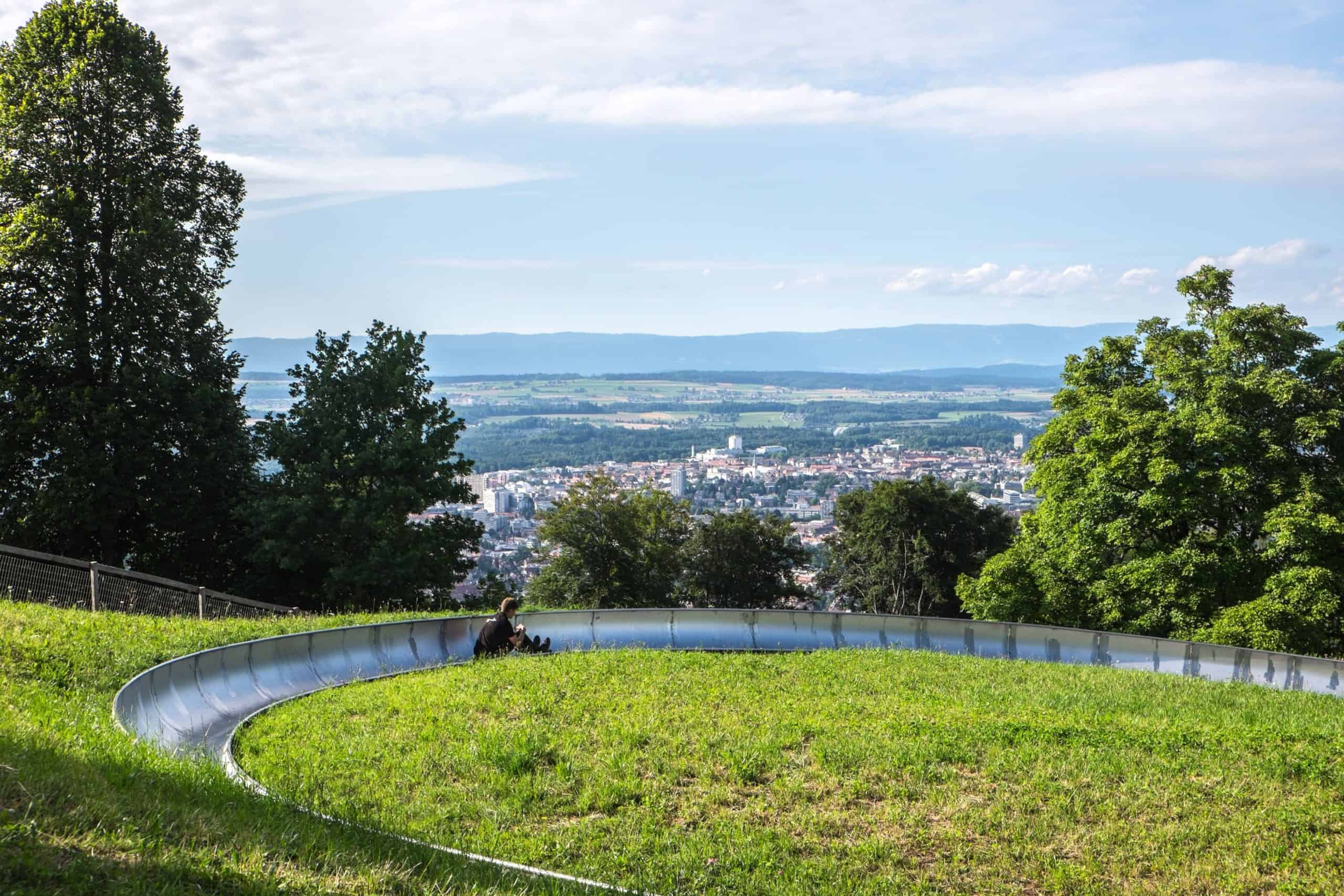A man rides the mountain toboggan overlooking Bern city, as it starts a decent 500m down an overall drop of 55m on one side of Gurten peak.