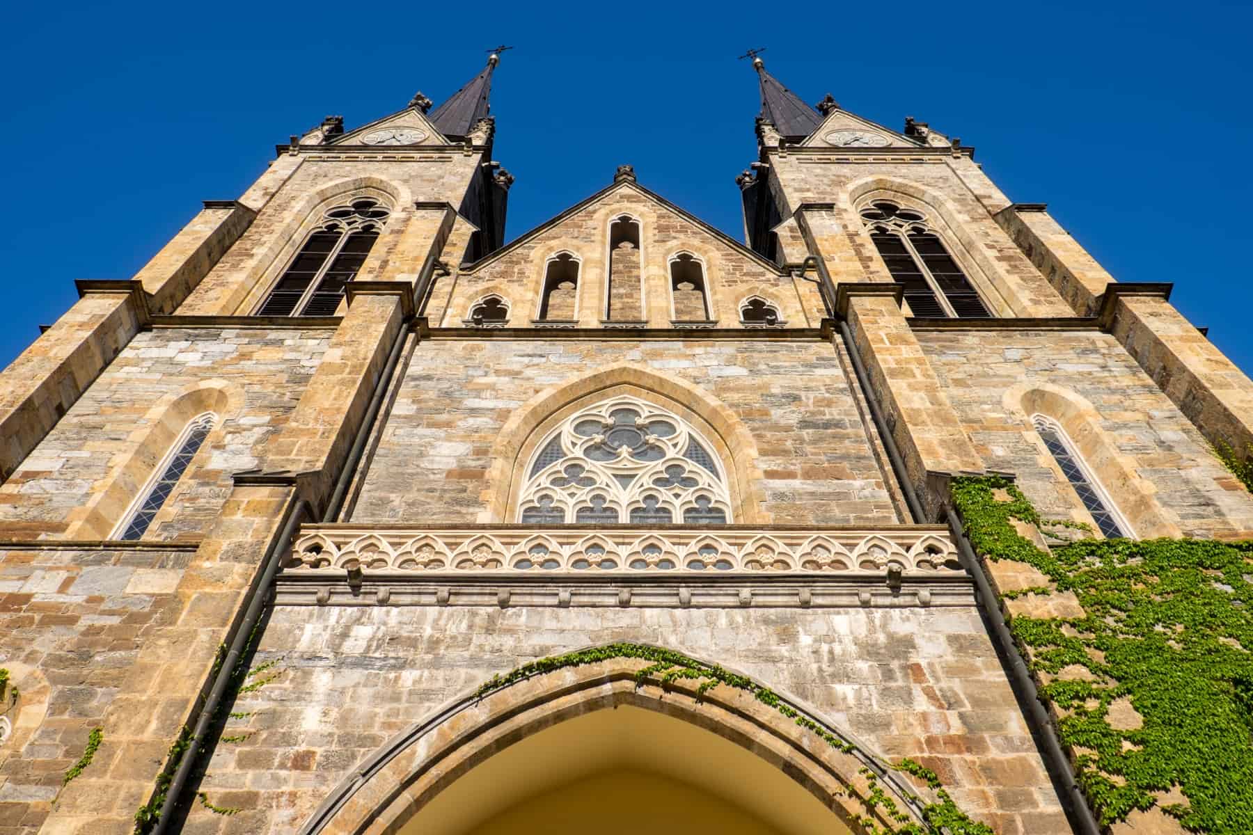 The golden brick facade of the twin towered, gothic Cathedral in St.Johann im Pongau, Austria