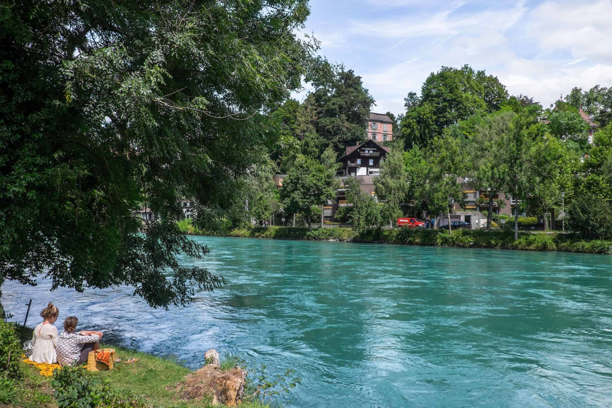 Two women relaxing next to the Aare river in Bern, Switzerland