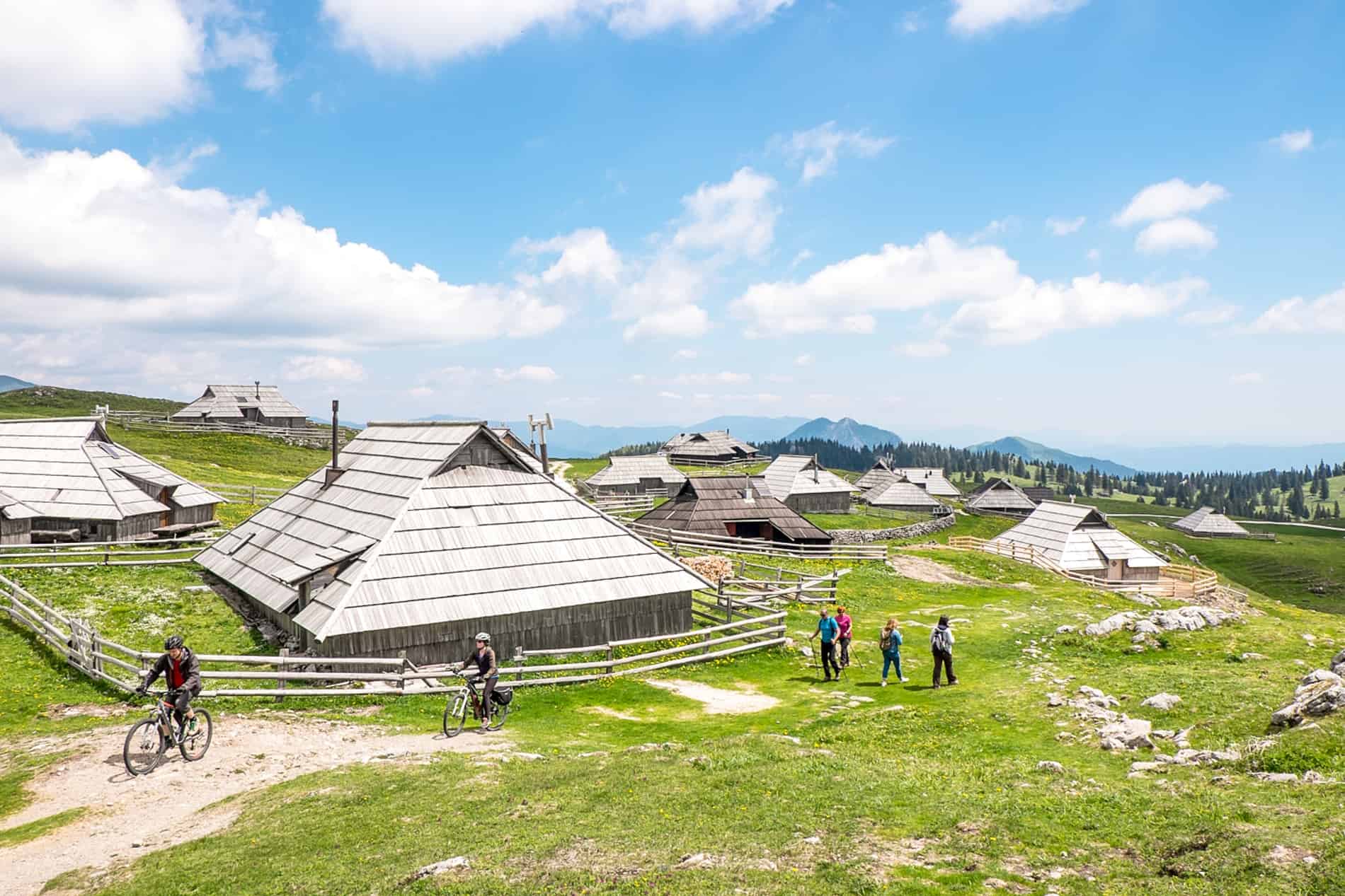 People visiting the unique silver triangular houses of the Velika Planina Shepherd Settlement in Slovenia.