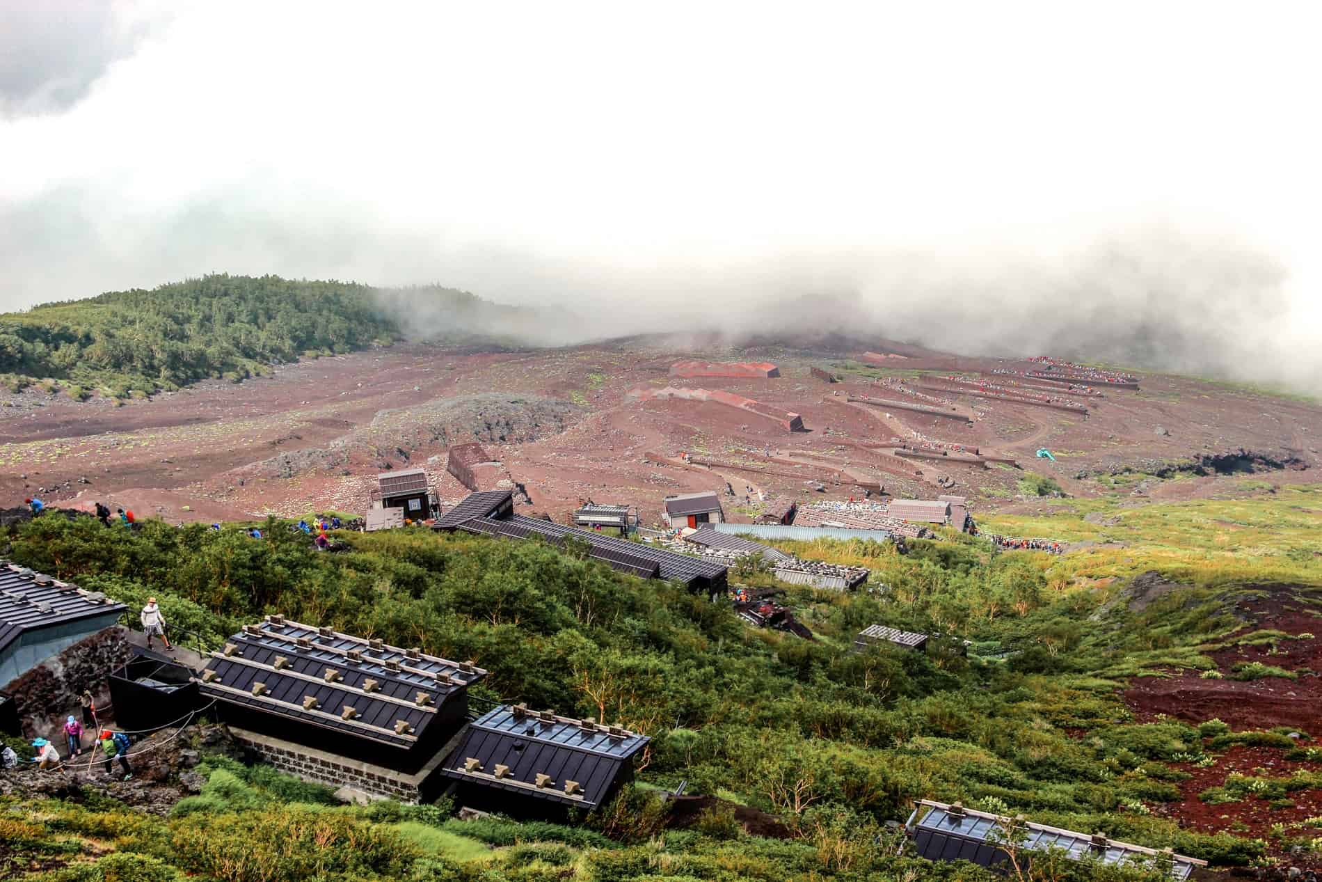 View of the zigzag Yoshida trail through red volcanic soil on the Mount Fuji climb. 