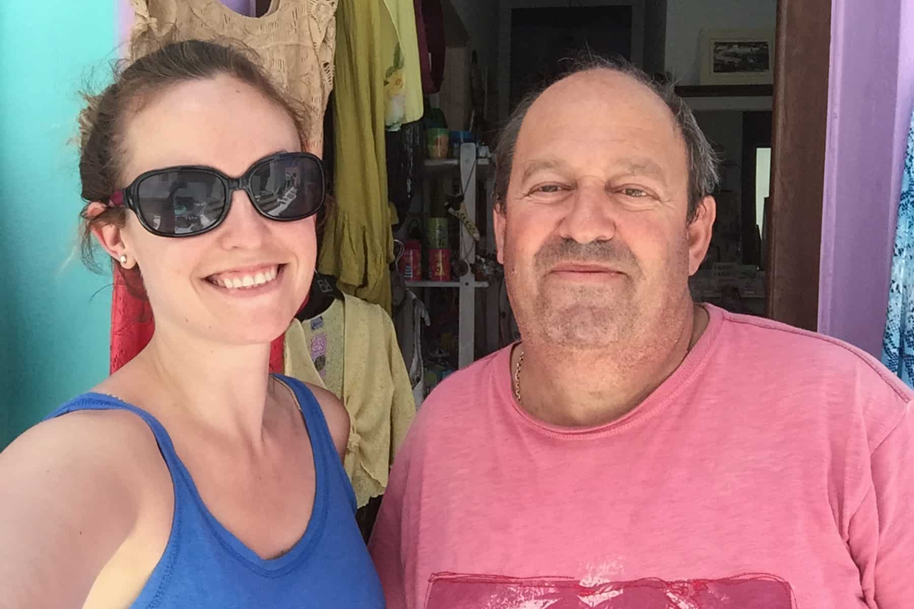 A woman wearing blue meets a local Greek man wearing pink on the Island of Kea