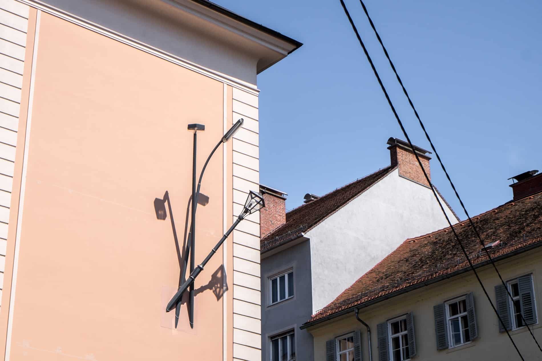 Public artwork of lampshades sticking out of the side of a building wall in Graz