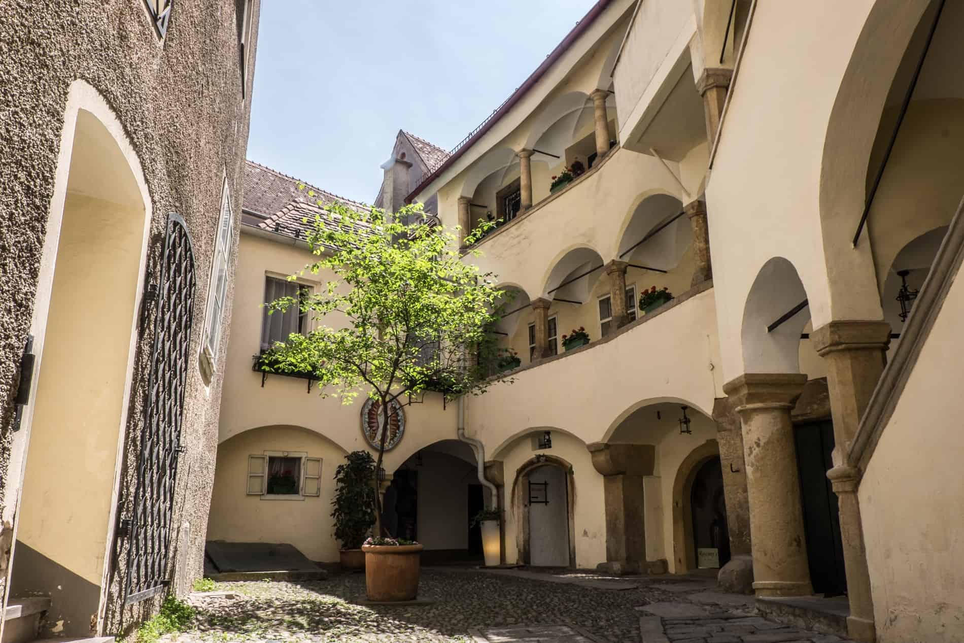 Inside the oldest courtyard in Graz city with arched windows and cobblestone pathways.