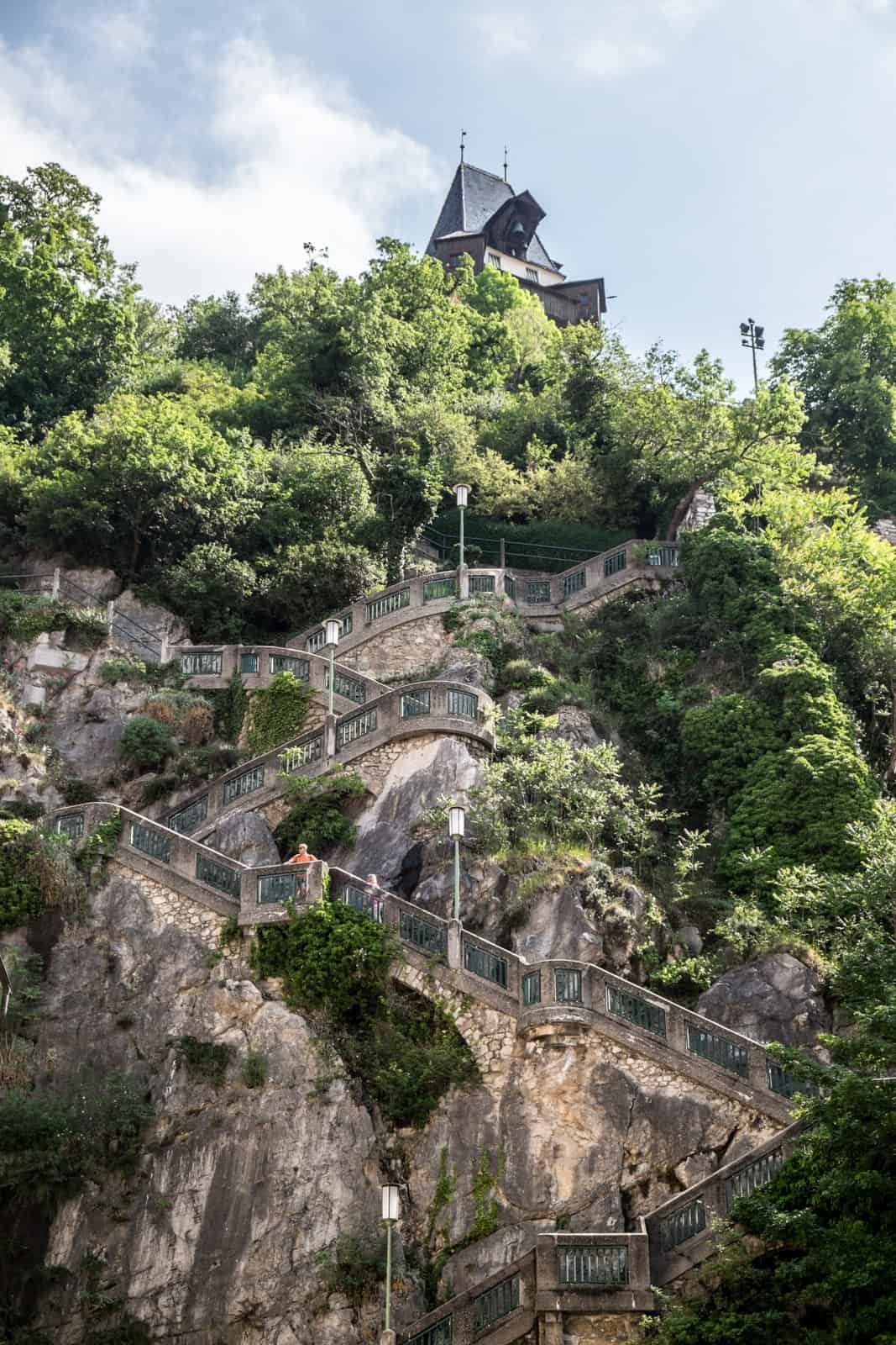 A zigzag staircase through the rocky Schlossberg mountain in Graz to the clock tower on top.