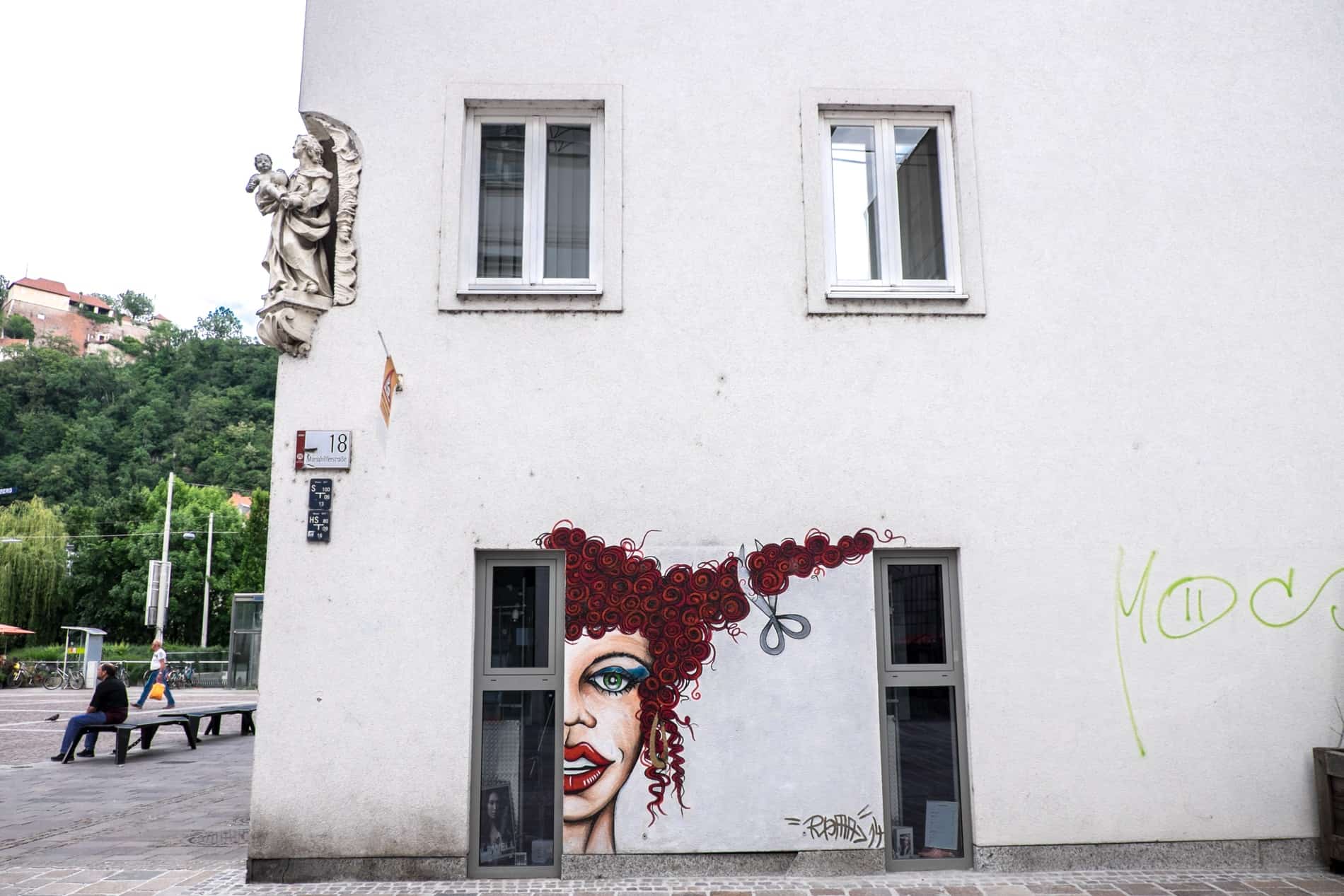 Street art of a woman having her hair cut to advertise a hairdresser in Lend, Graz.