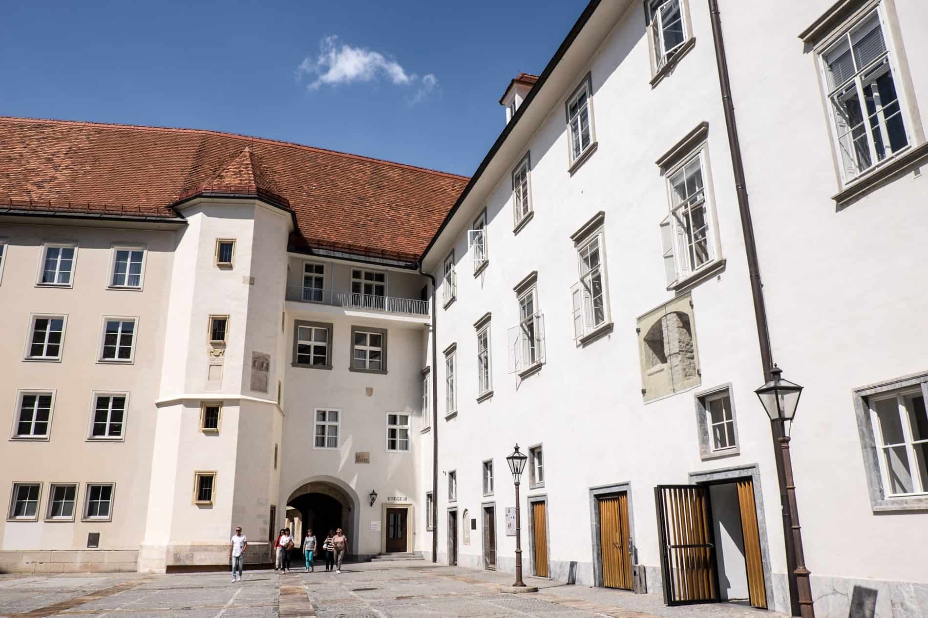 The white facade, turret columned, castle like building of the Burg building in Graz.