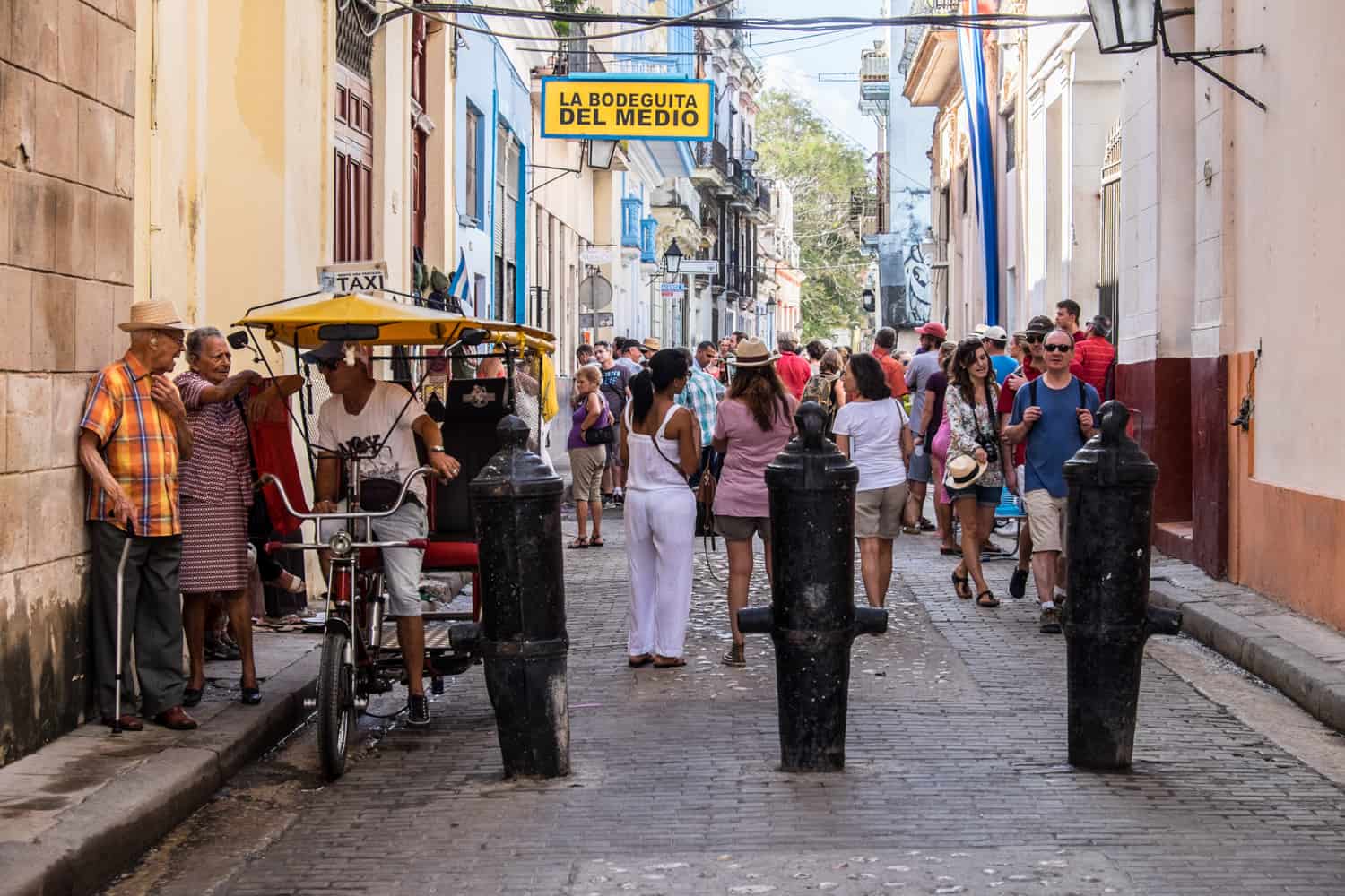 Cuba tourism in Havana on the street outside La Bodeguita Del Medio bar and its famed yellow sign. 