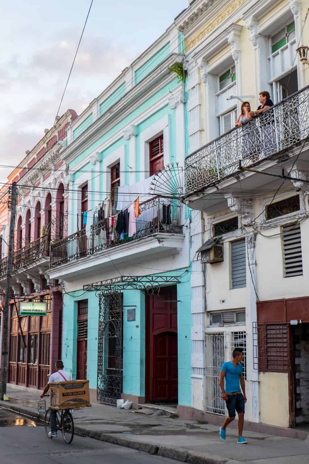 A street scene in Havana Cuba, with colourful houses and people. 