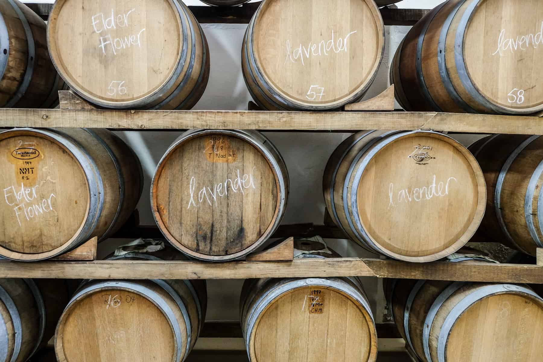 9 wooden barrels in view, stacked on three rows and some bearing the words 'lavender' and 'elderflower' - all Vinegar barrels at Rozendal Guest Farm