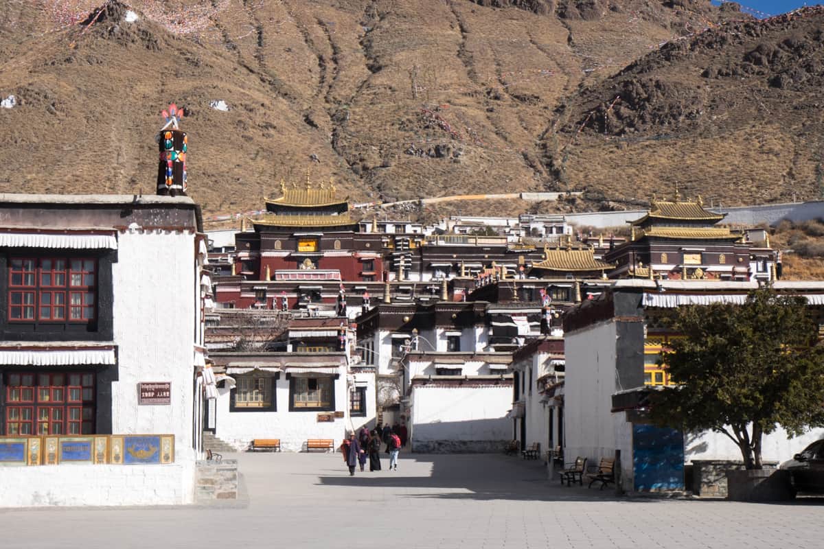 Wide view of the red, gold and white layered buildings of the Tashi Lhunpo Monastery in Shigatse Tibet