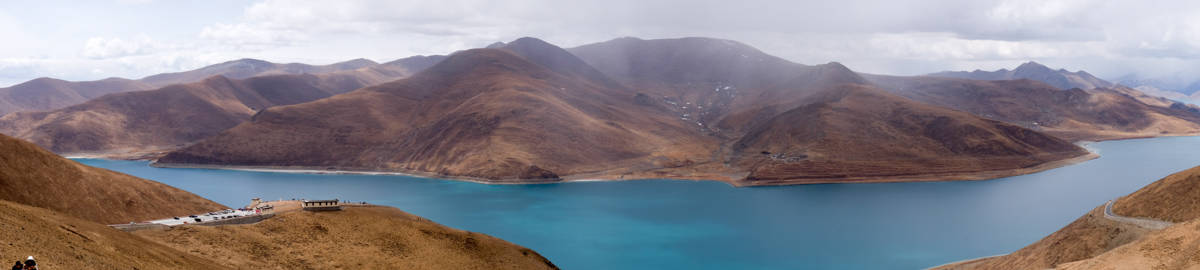 Panorama view of Yamdok Lake and surrounding mountains from a roadside viewpoint in Tibet