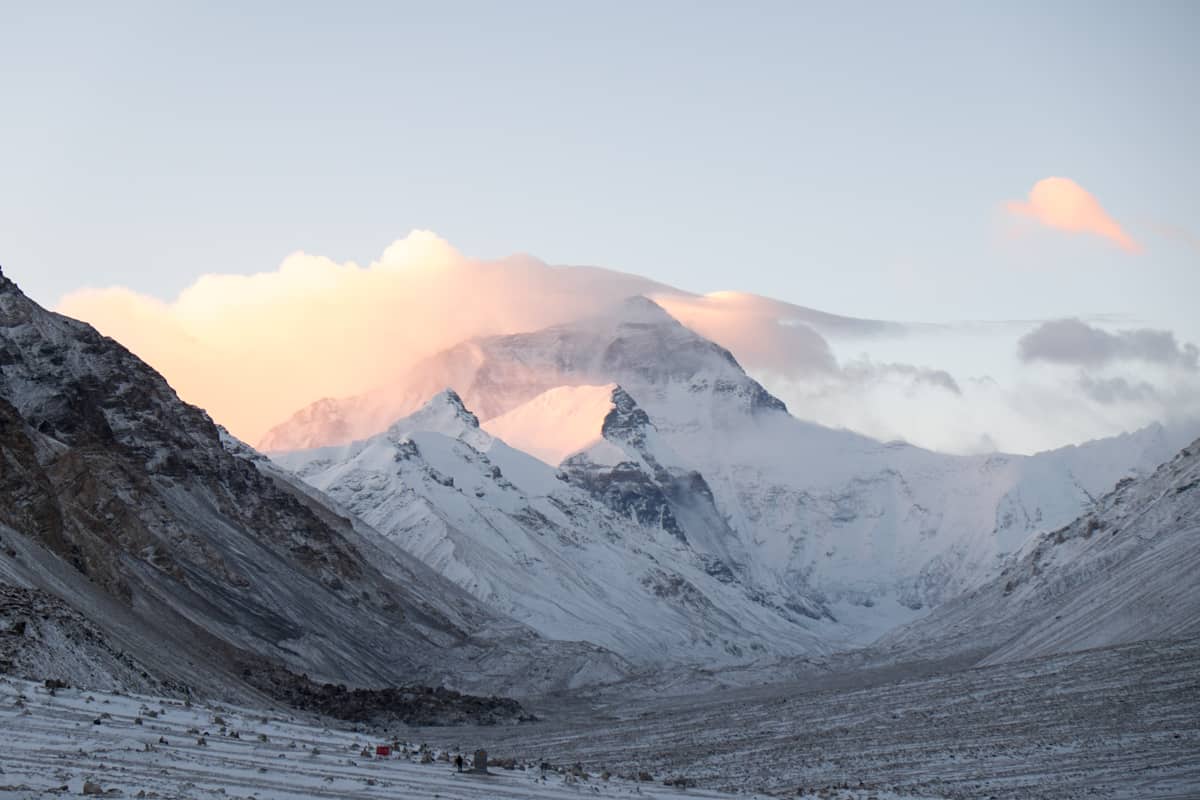 View of Mount Everest covered in snow with a golden glow from the morning sun clouds at Everest Base Camp Tibet