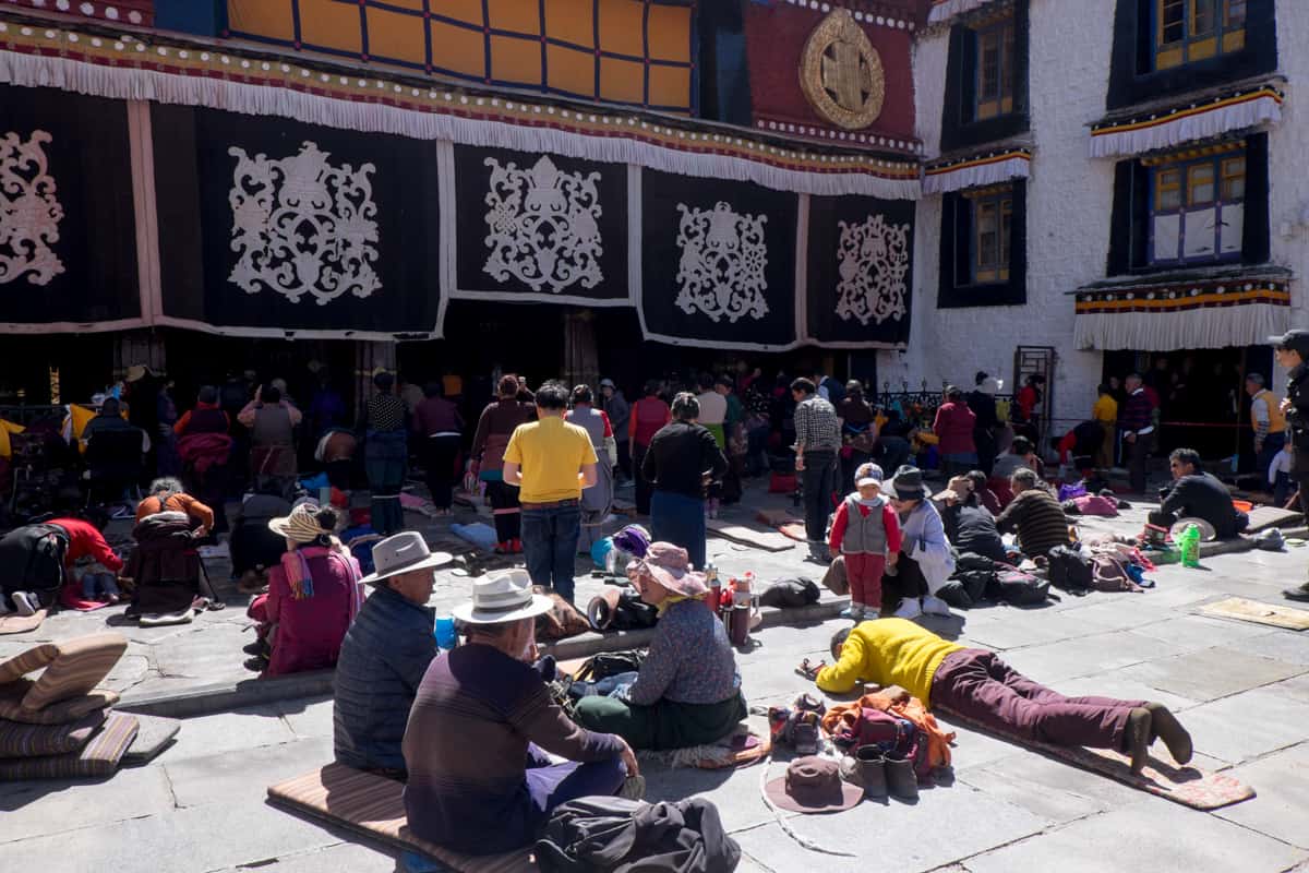 Praying Tibetans on the floor outside the main entrance of the Jokhang Temple in Lhasa, seen when you travel Tibet