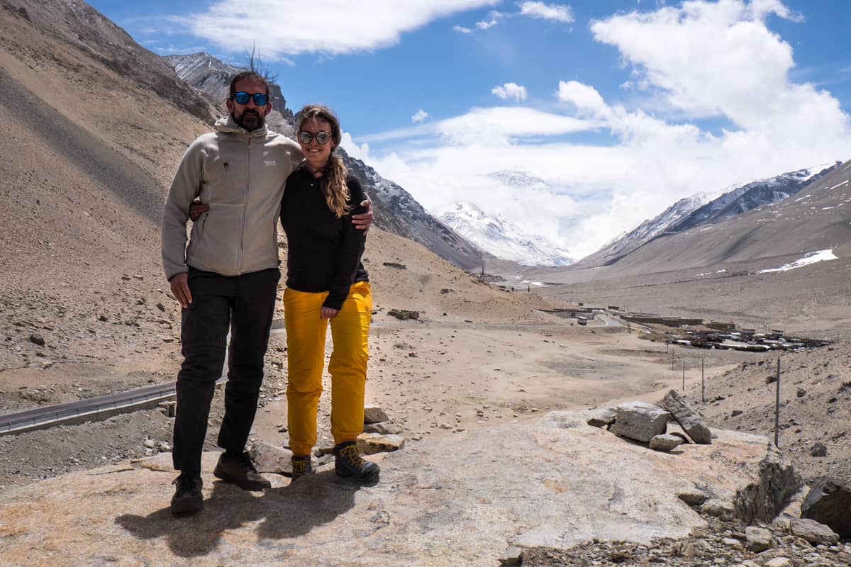 man and woman stand on a hillside with a Mount Everest view near Everest Base camp during a Tibet Travel Tour