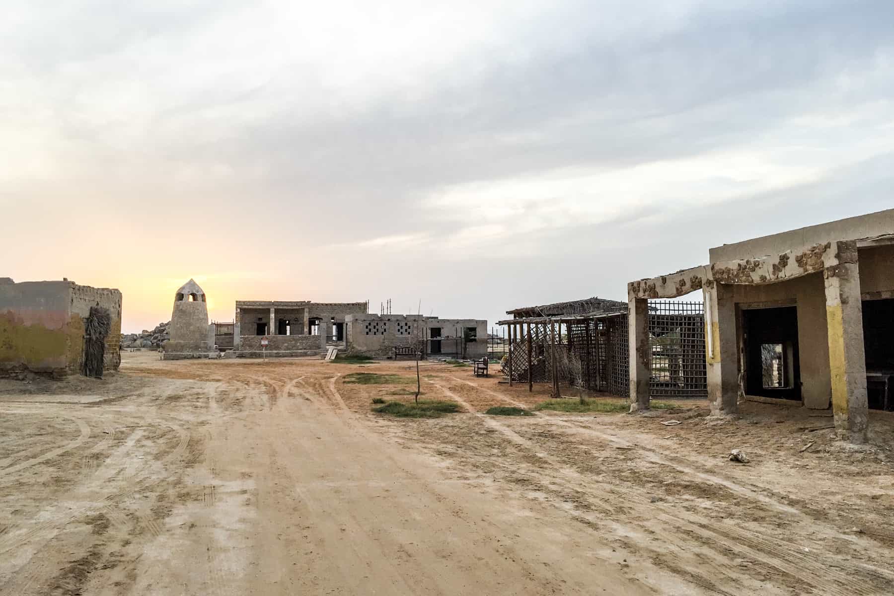 A far few of the abandoned buildings of Al Jazirat Al Hamra village in Ras Al Khaimah. A ghost city with shells of buildings left in the desert sands. 