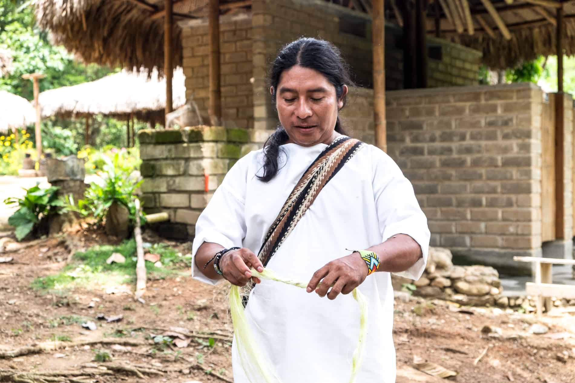 A member of an indigenous Wiwa village in Sierra Nevada Colombia demonstrates how to make rope from plants. 