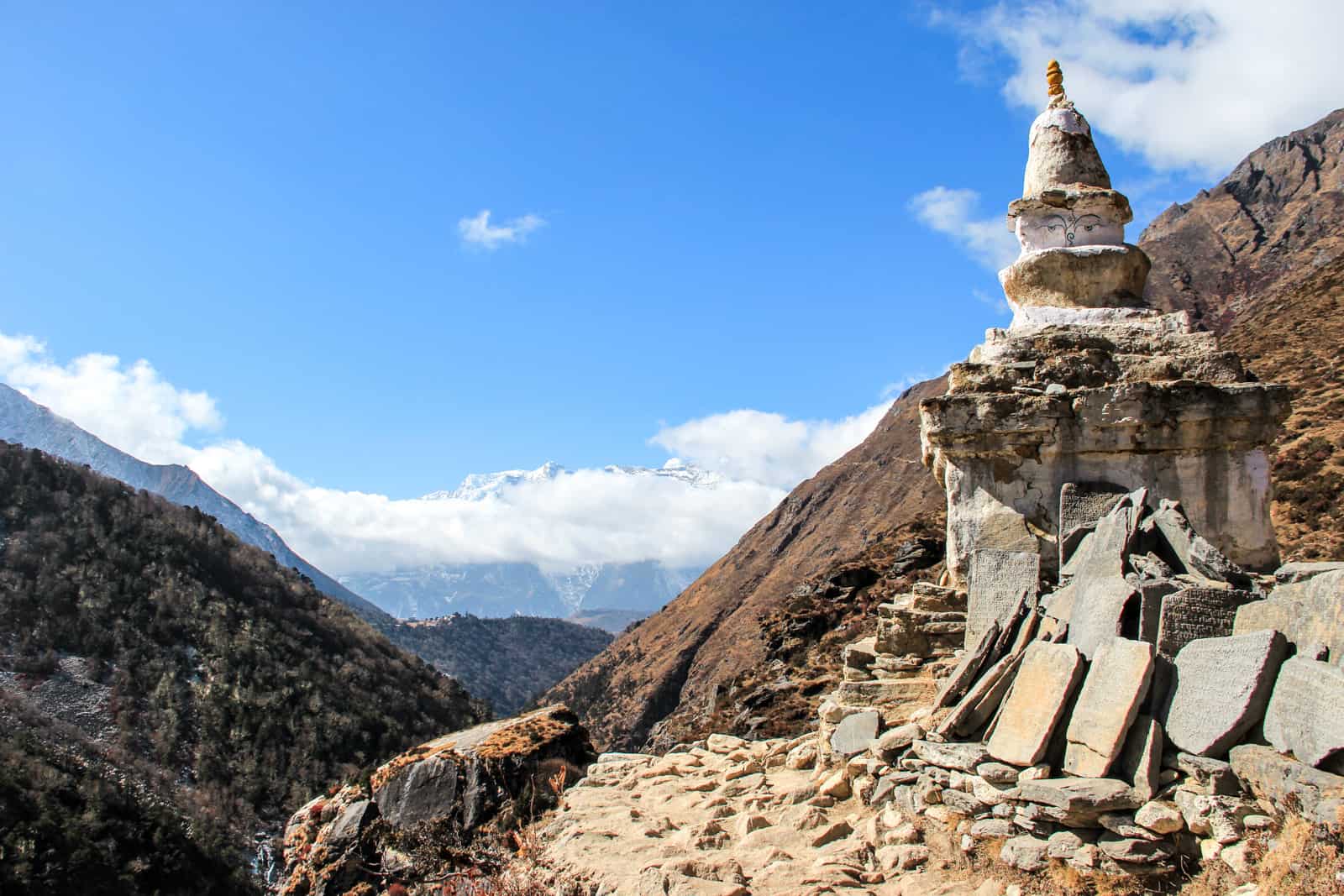 Rock temple in Himalayas, perched on the side of a brown mountain ridge on the Everest Base Camp trek