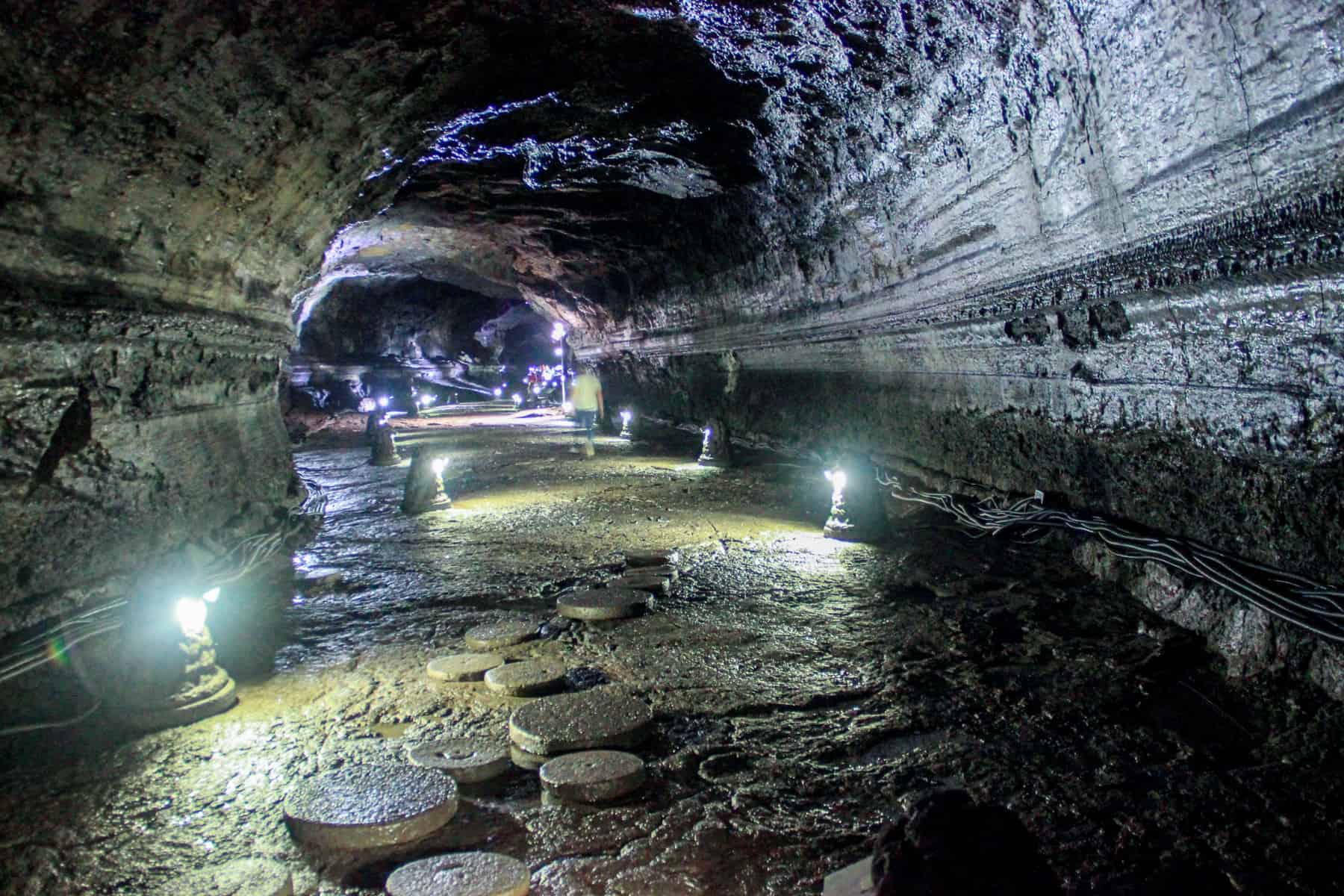 Inside The wide and high, blue and yellow lit Lava tube cave, one of the best things to do in Jeju Island