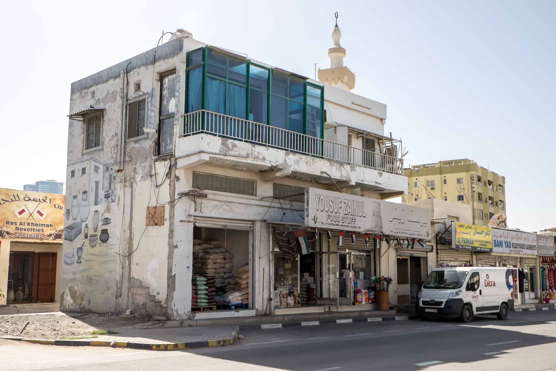 A small row of store-fronts in Ras Al Khaimah selling food and home wears