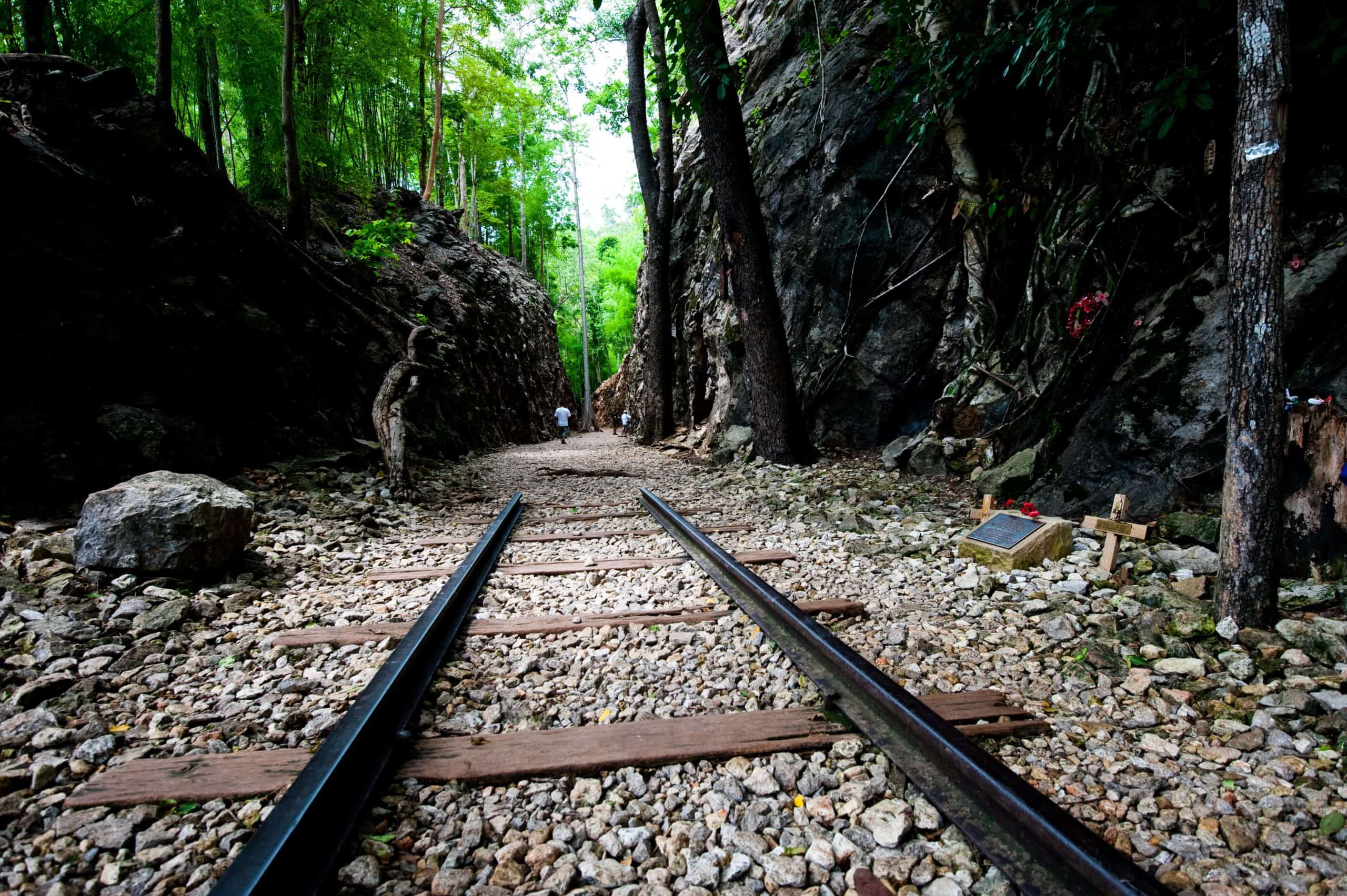 The remains of a rail track on a rocky path between two high cliffs - part of the Death Railway track in Kanchanaburi, Thailand.