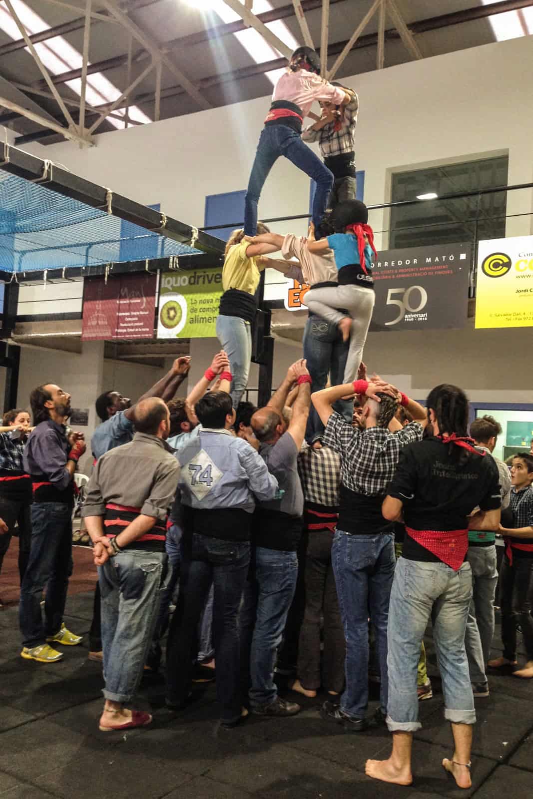 A group of people holding up others as part of the Catalan Human towers tradition in Girona, Spain.