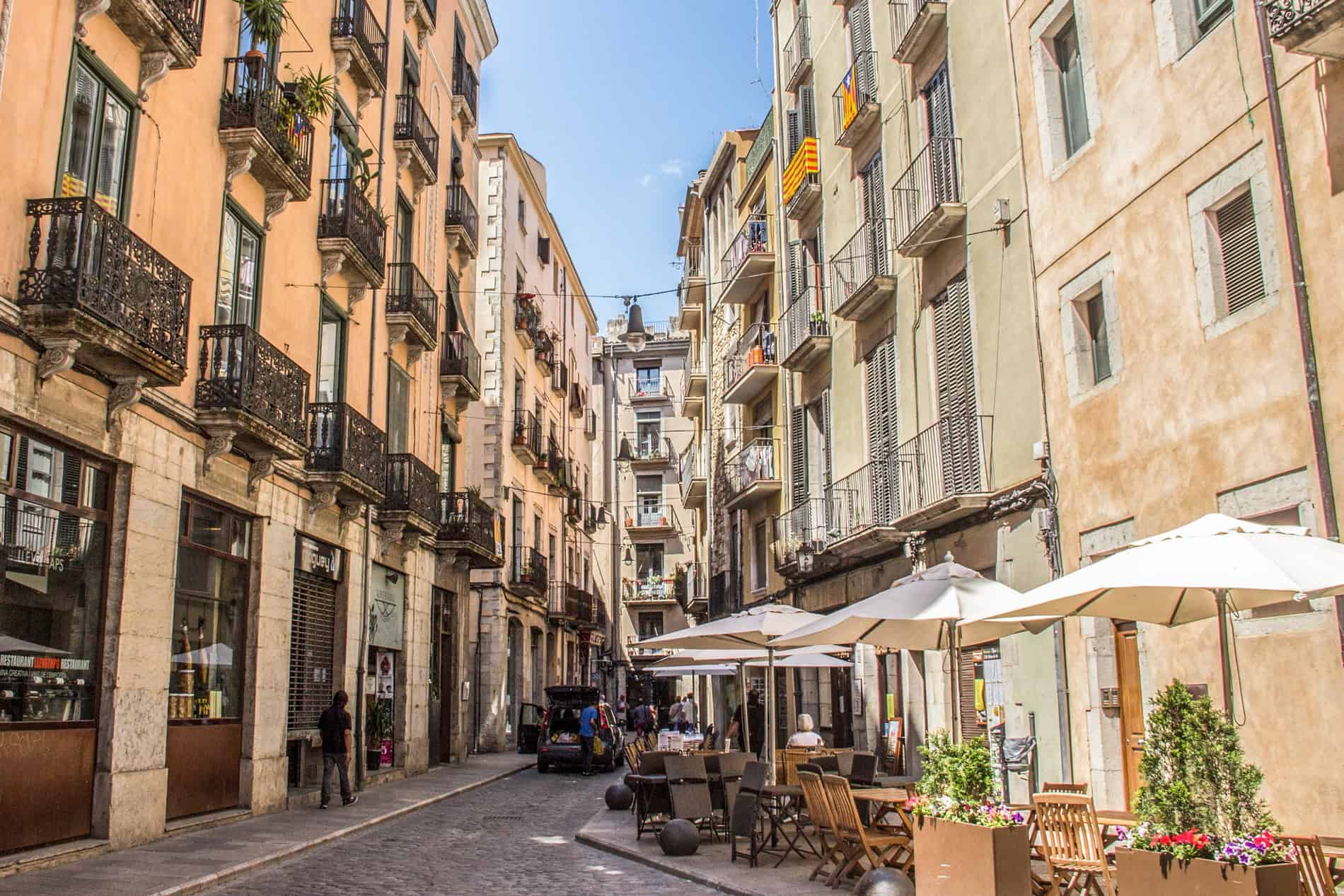 A street of balconies buildings in old town Girona converges to a narrow point. 