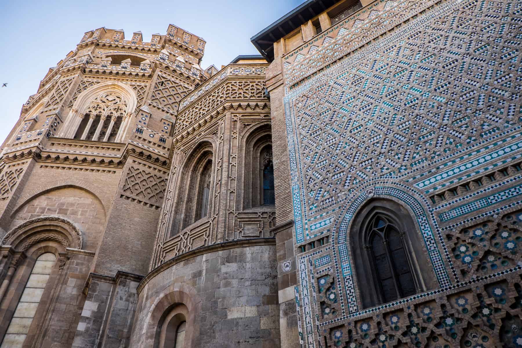 The intricate, patterned bright blue and golden tiles and carvings on the exterior of some historical buildings in Zaragoza, Spain. 
