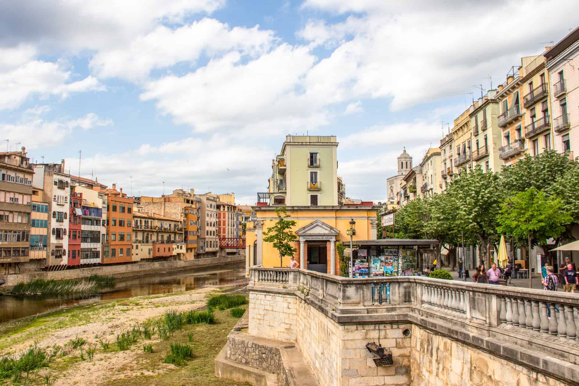 View of the modern structures of riverside Girona, as seen from a bridge. 