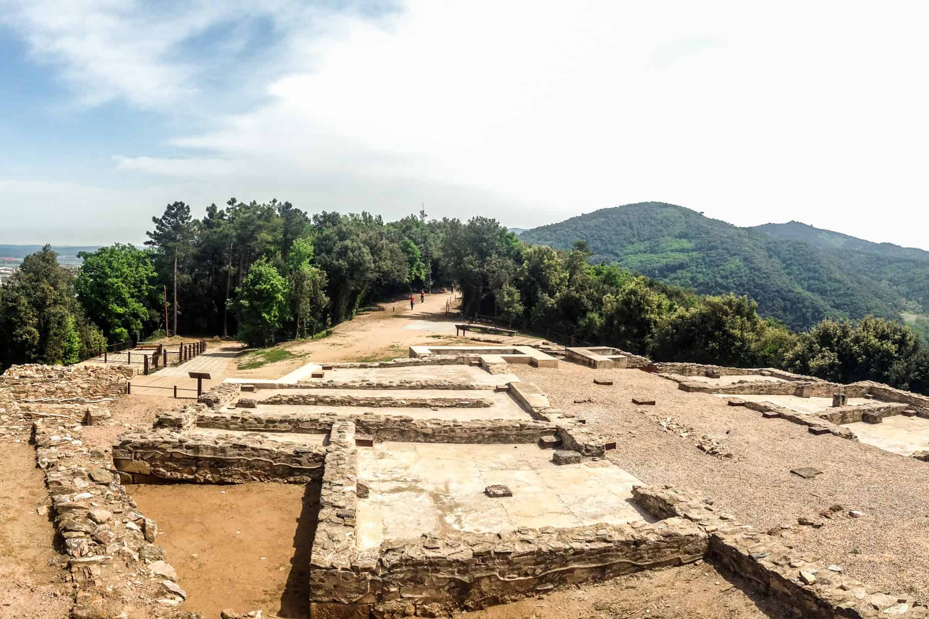 The stone ruins foundations of the Iberian Castle 'Castellum Fractum’ atop a Costa Brava forested mountain. 