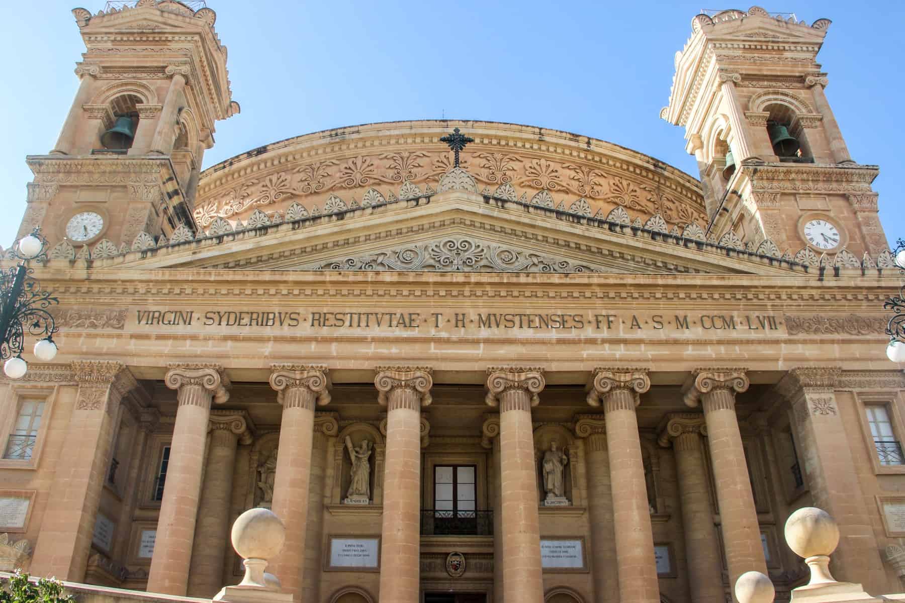 The two clock towered, six columned, carved curved roof of Mosta Dome in Malta. 
