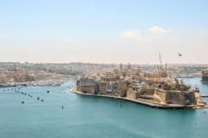 The timeworn, caramel architecture of Malta island on turquoise blue sea.