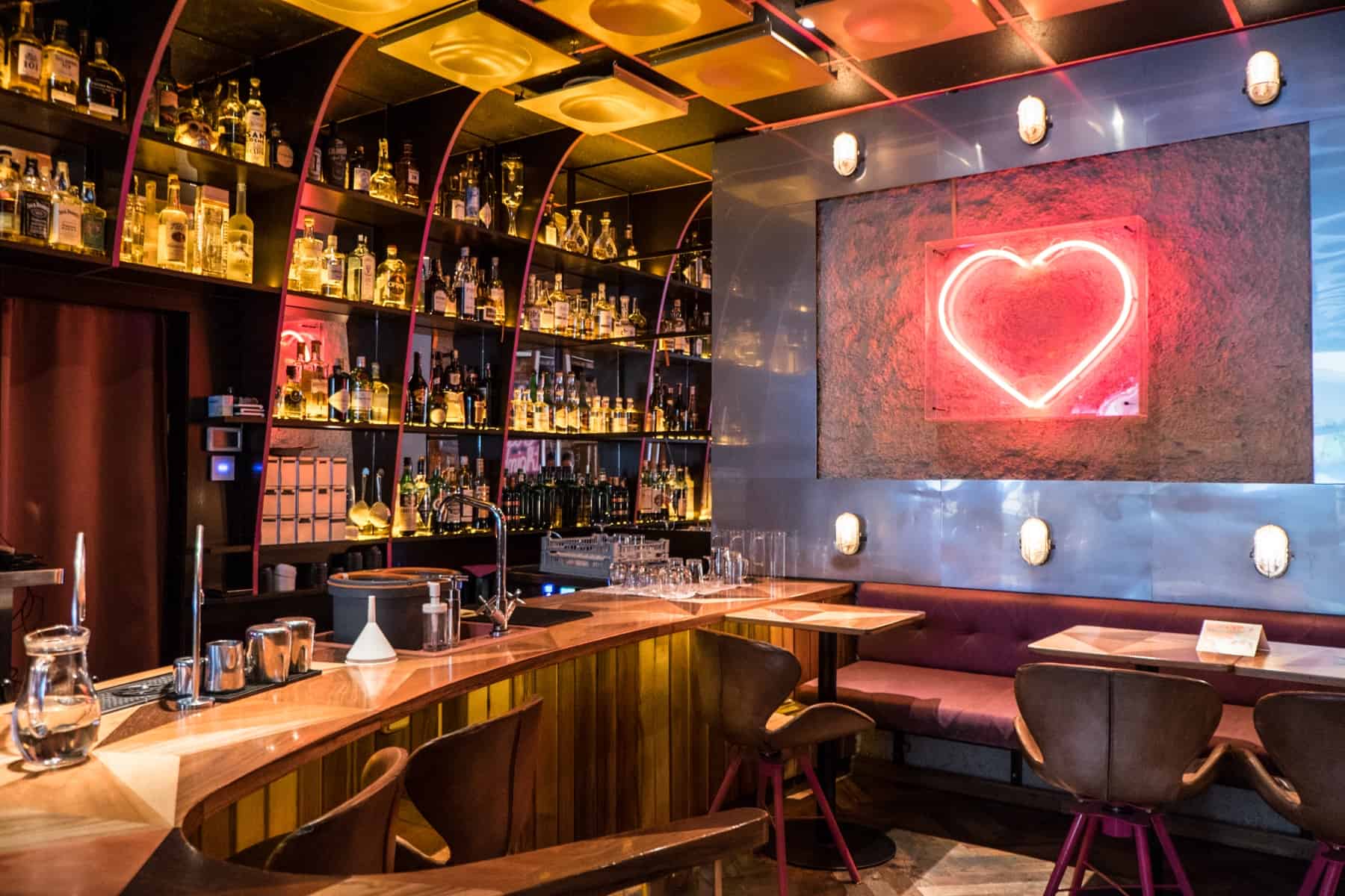 brno places to visit The retro, wooden decor, golden lit and red neon heart light bar at 4pokoje bistro in Brno, Czech Republic.