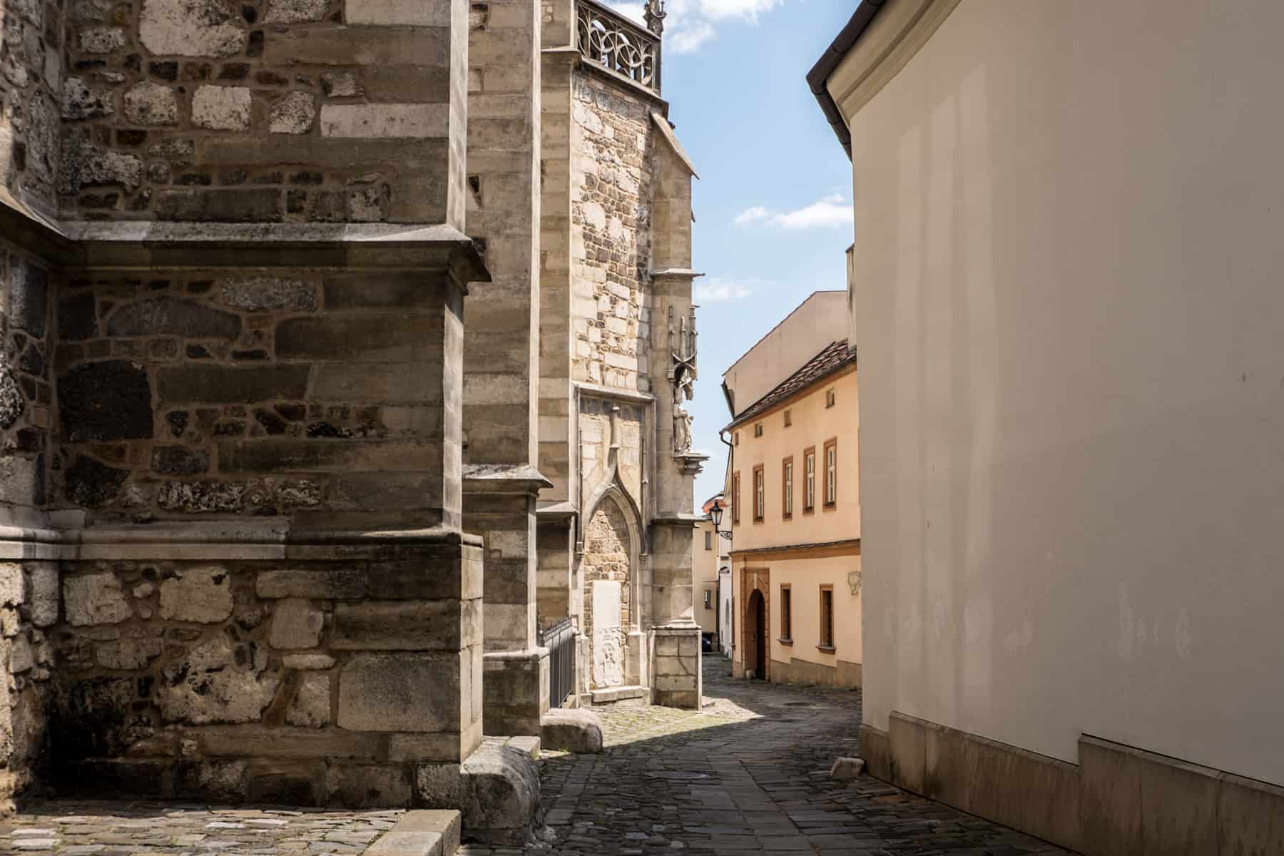 brno places to visit The cobblestone streets next to the old stone Cathedral of St James and St Paul (left) and old low-rise buildings (right) in Brno.