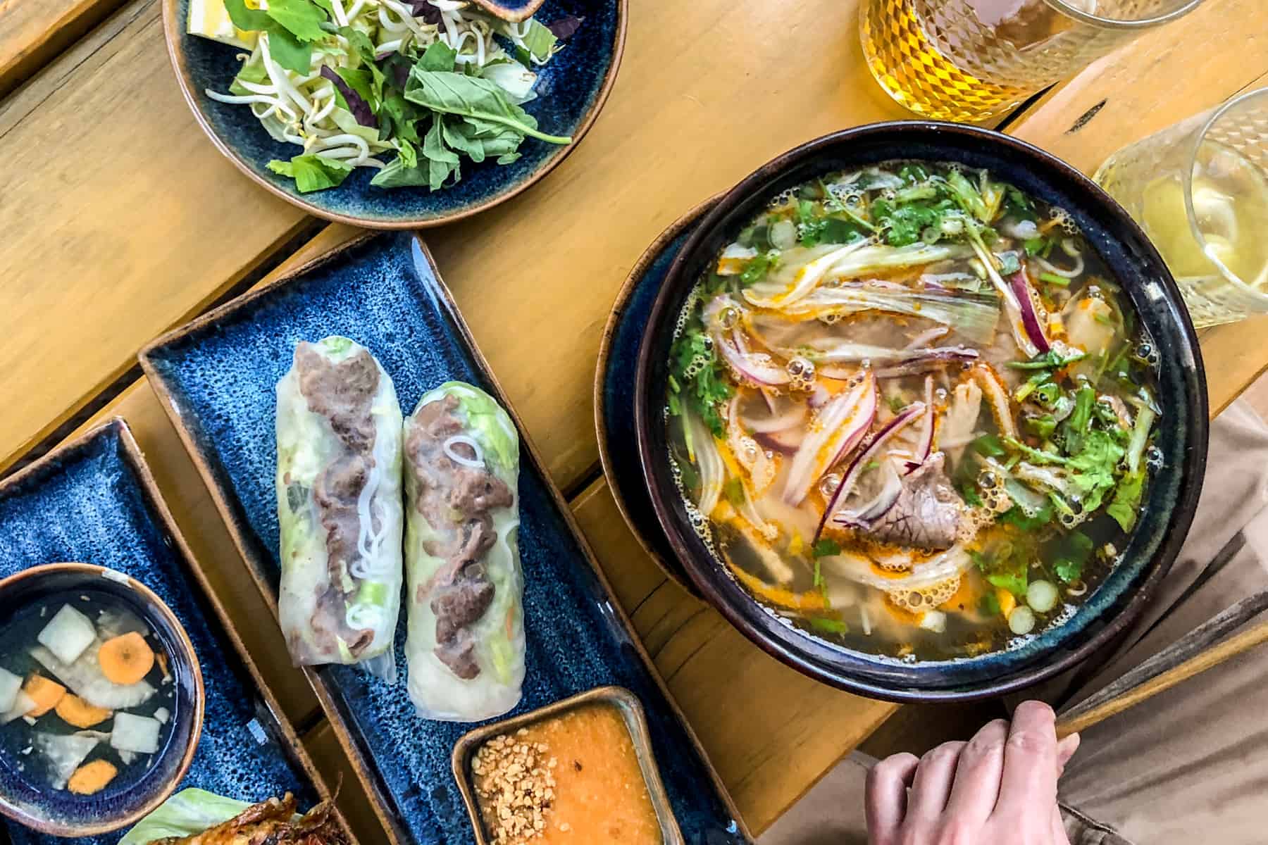 brno places to visit Pho, springrolls and salad served on electric blue plates as one of the best Vietnamese restaurants in Brno.