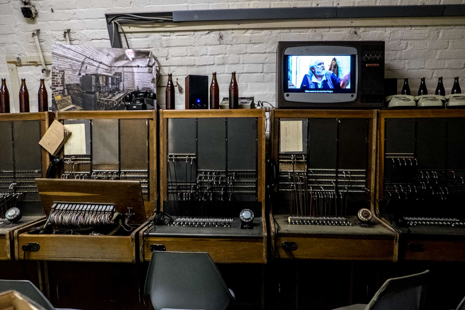 brno places to visit Old communications machines, wires and empty beer bottles in the 10-Z Bunker in Brno. A TV playing a video rests on top, as part of the exhibition.
