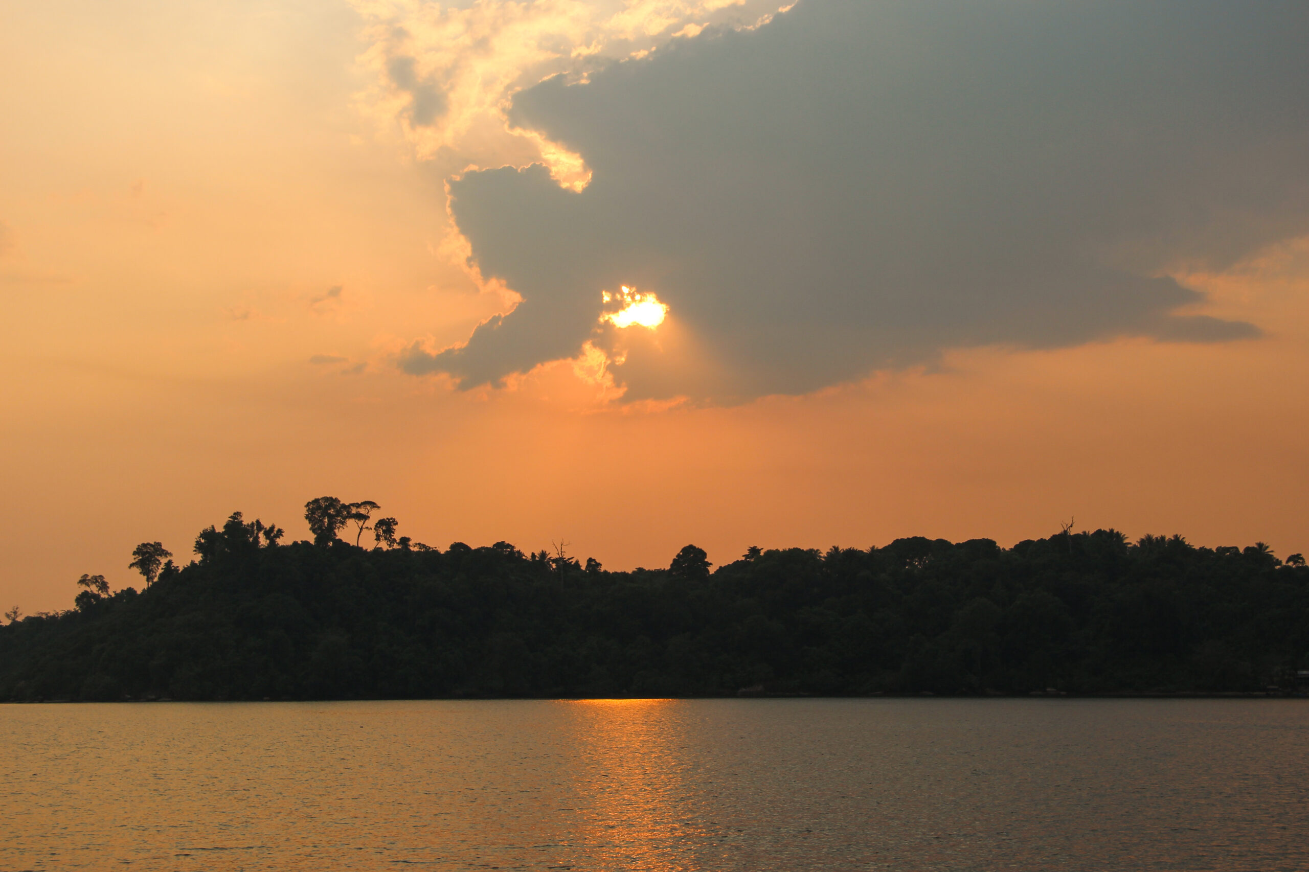 The sun setting over a long stretch of jungle on Koh Kong Island.