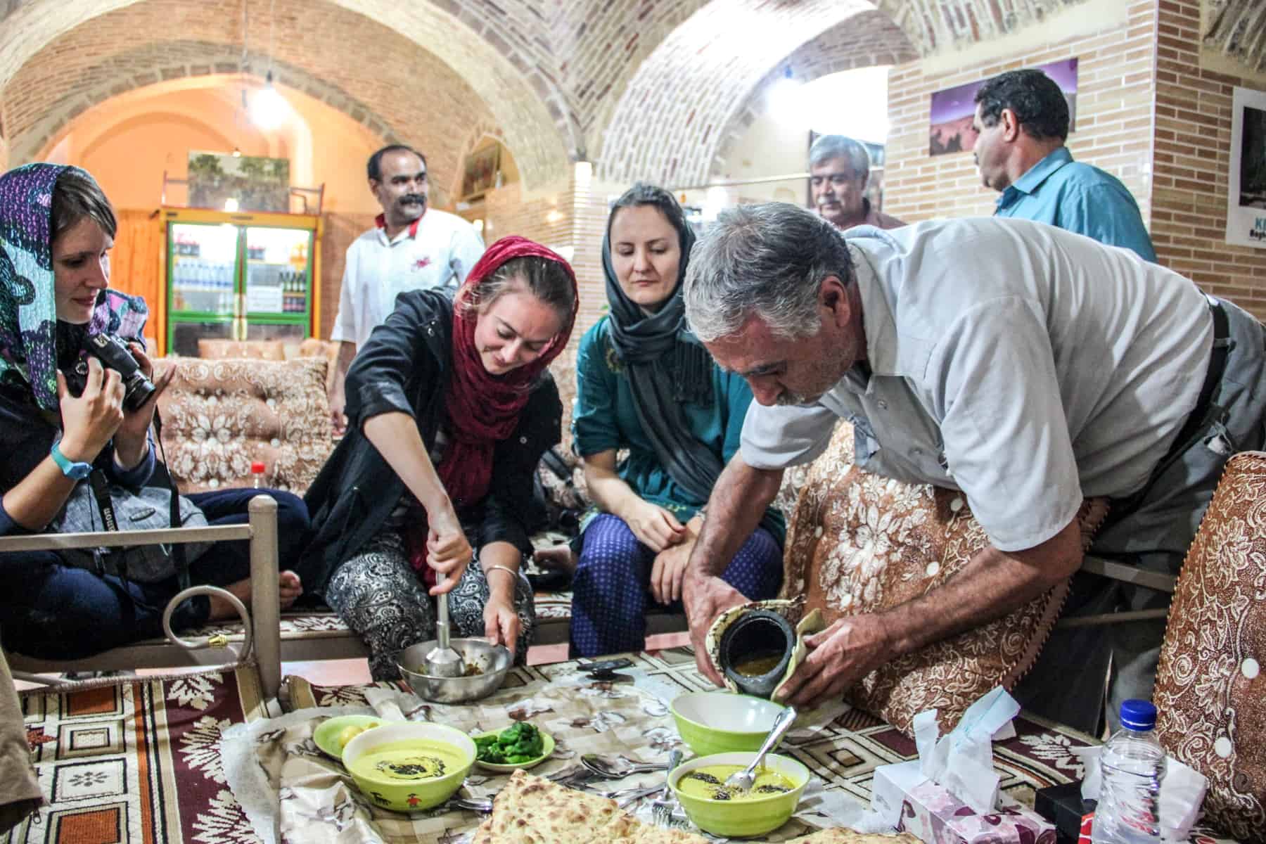 Tourists in Iran trying Persian food with locals. 