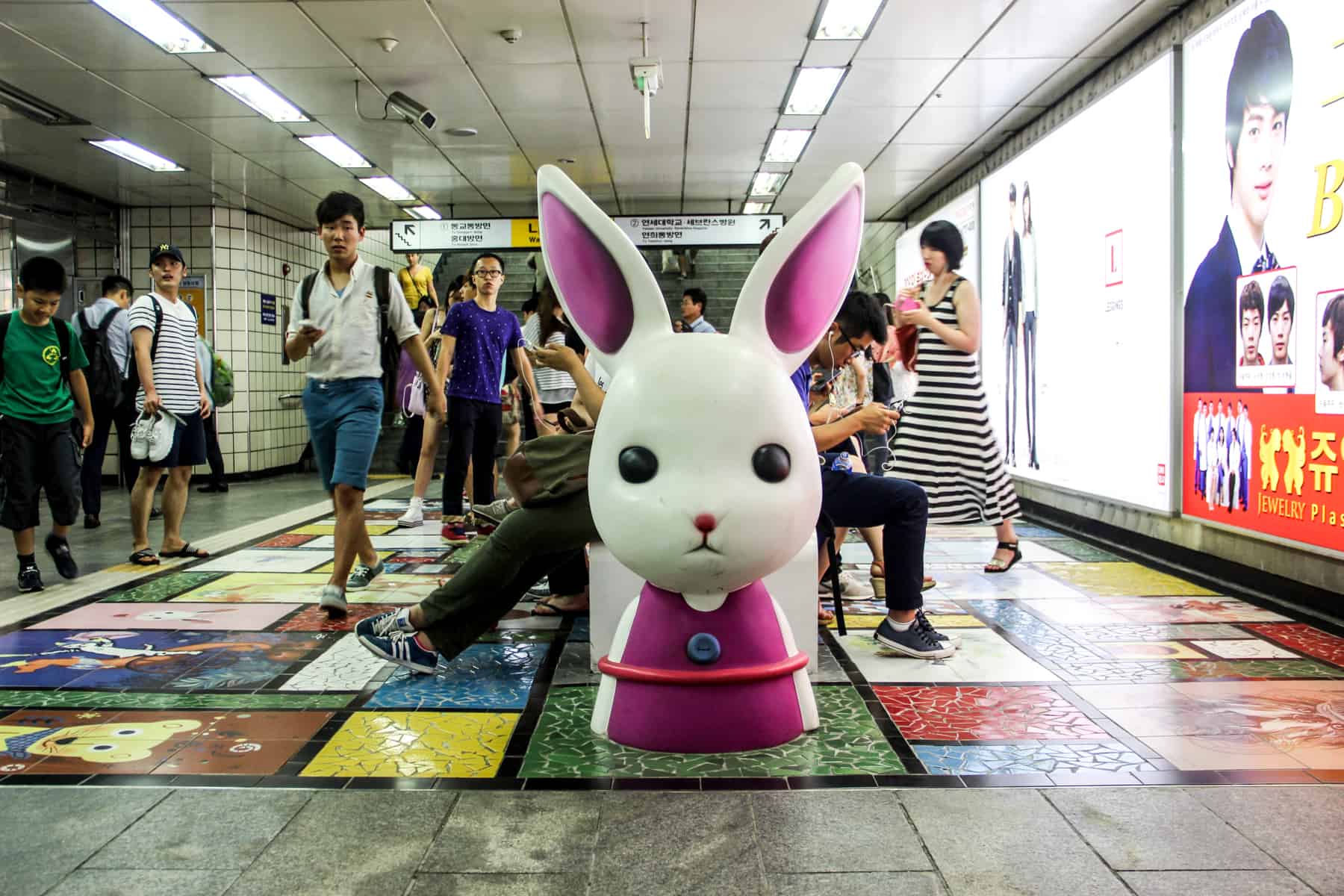 People sit on a bunny decorated bench inside Seoul's metro station in South Korea. 