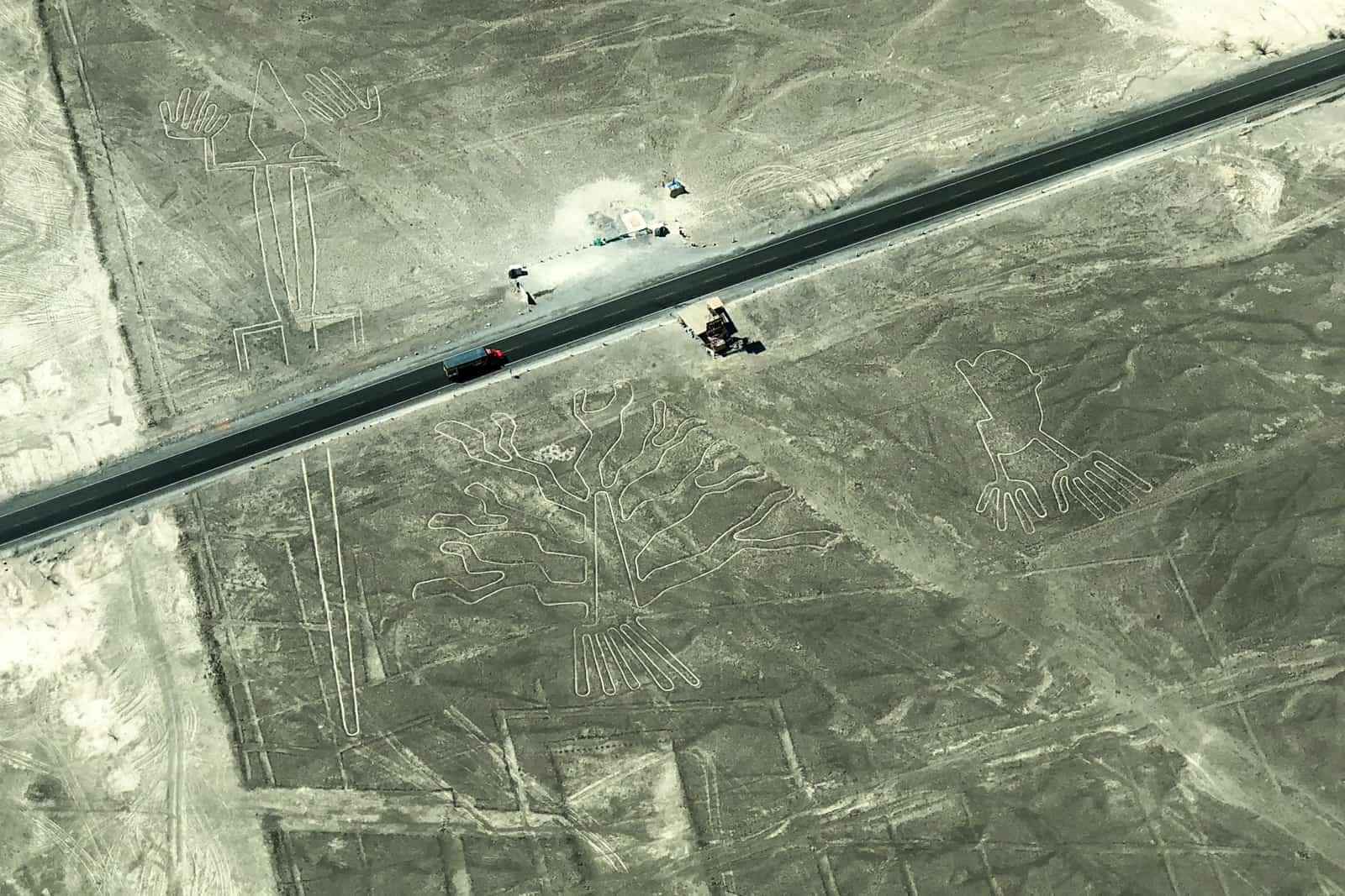 A road cuts through some of the Nazca Lines in Peru, where a viewing tower has been placed.