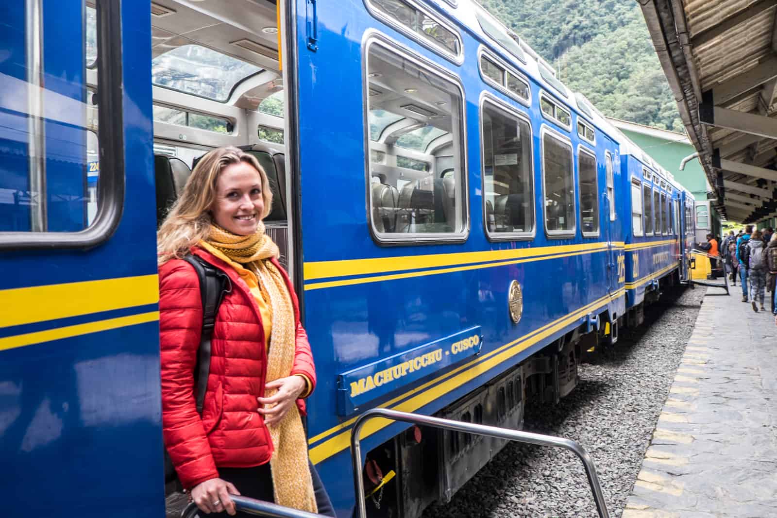 A Passenger disembarks the blue and yellow Peru Rail train to Machu Picchu. 