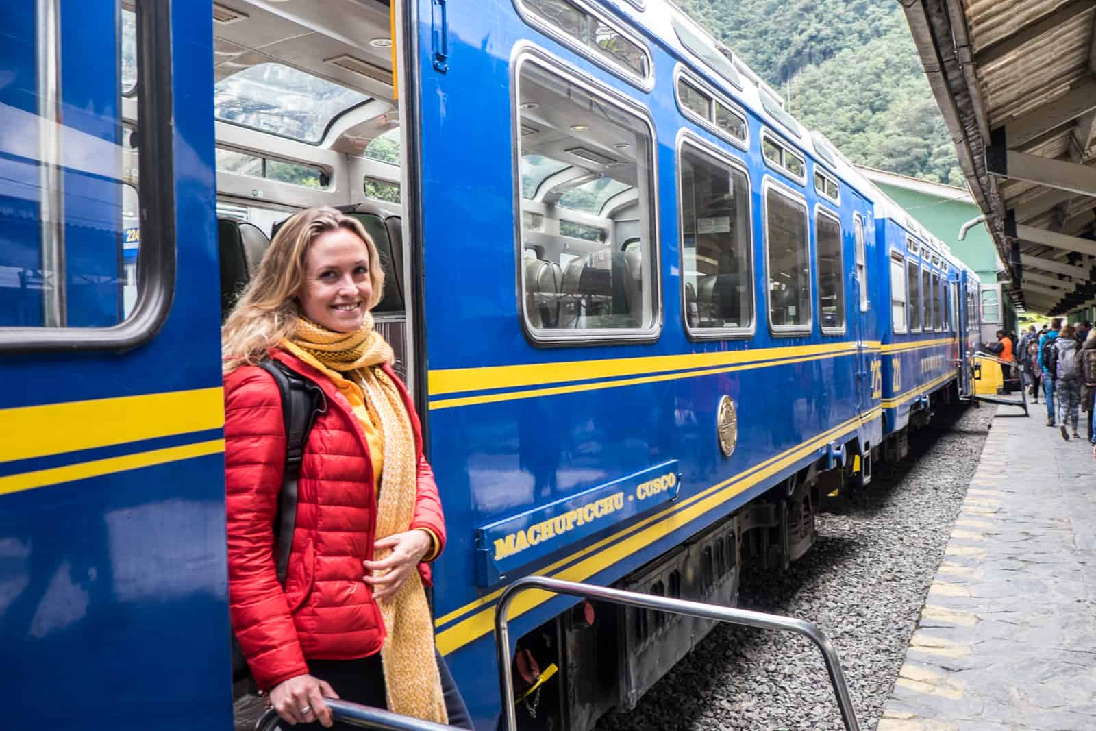 A Passenger disembarks the blue and yellow Peru Rail train to Machu Picchu.